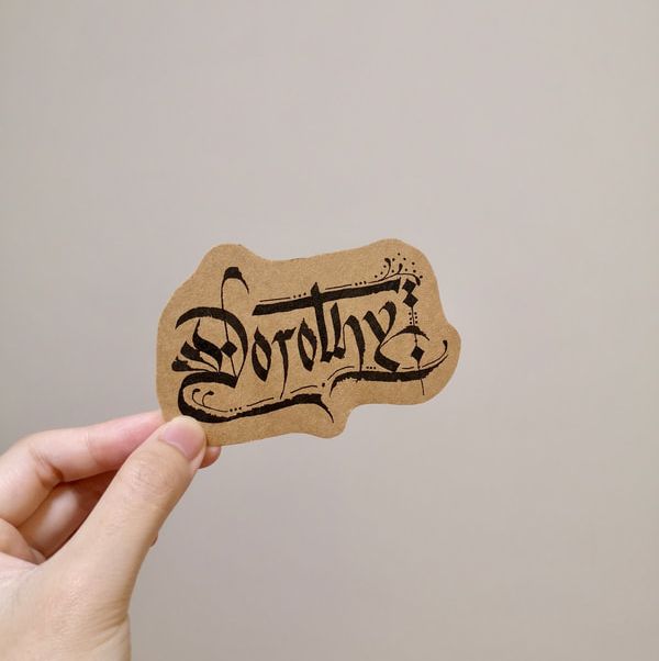 Blackletter gothic calligraphy on a wooden tag
